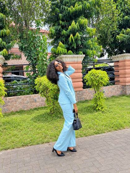 Powder blue blazer and wide-leg trousers styled with a black bag
